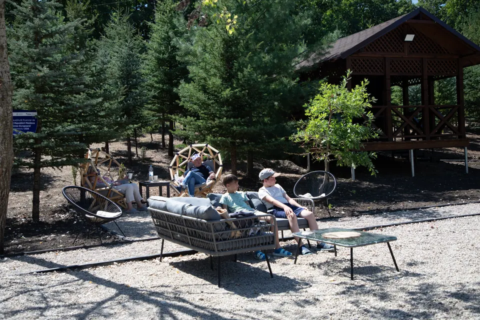 Familie relaxându-se în aer liber lângă un foișor DendroPark