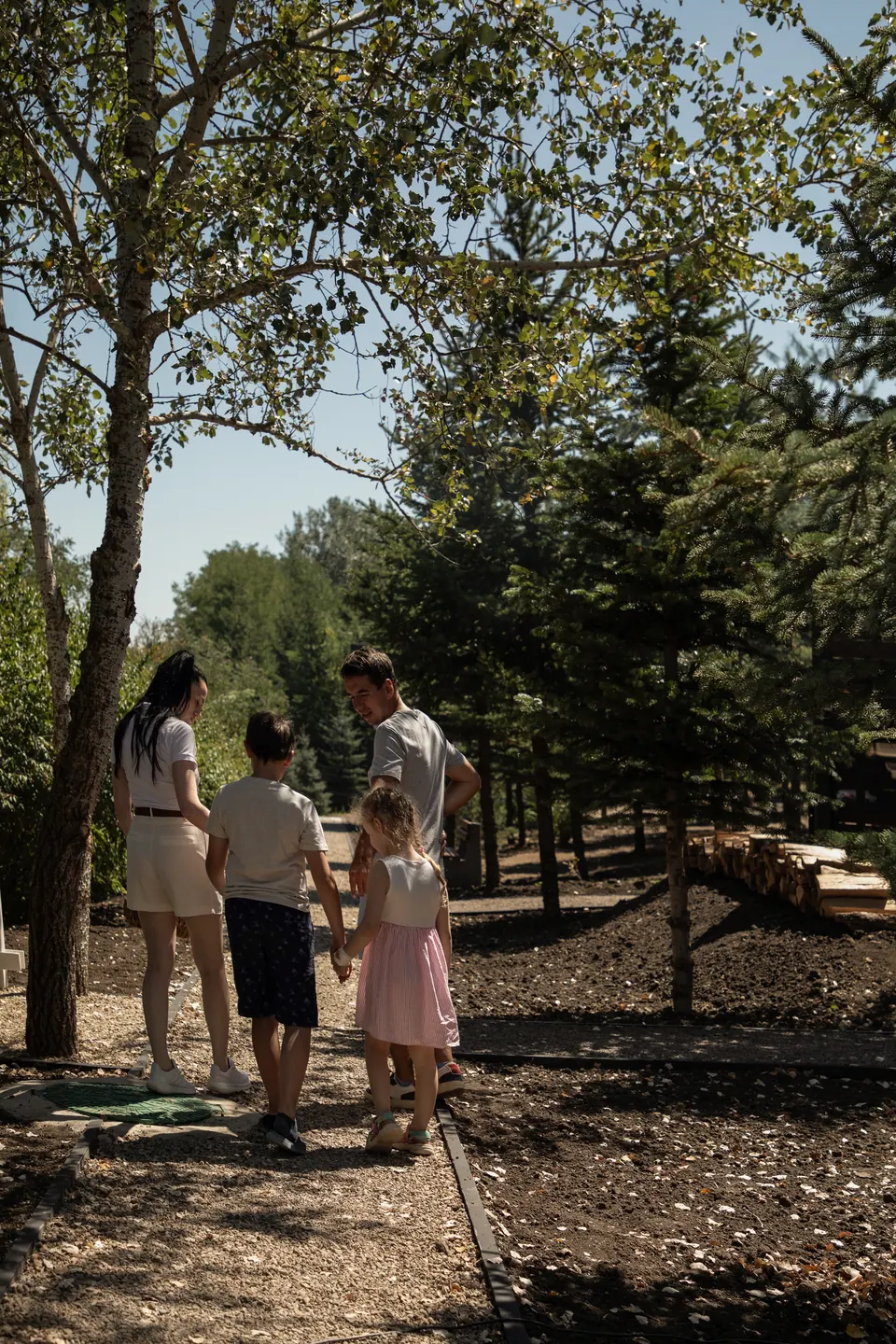 Familie plimbându-se pe o alee umbrită prin parc